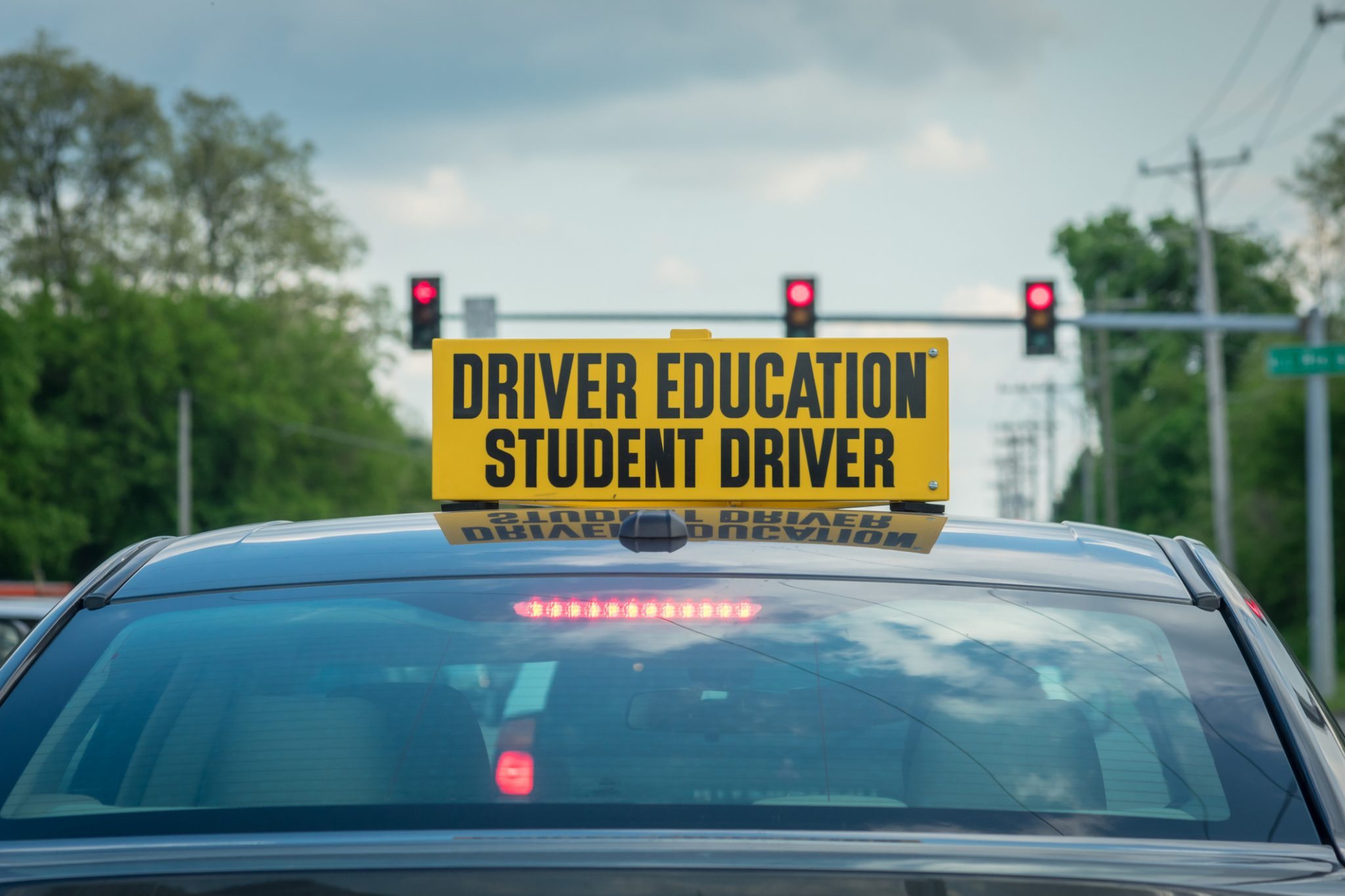 Student driver sign on top of car at stoplight Traffic Injury