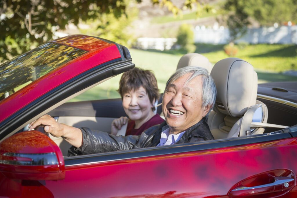 Attractive Happy Couple Enjoying An Afternoon Drive in Their Convertible.|