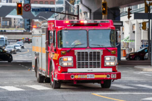 A fire department truck rushes on a downtown avenue during the daytime