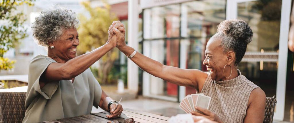Senior women friends playing cards