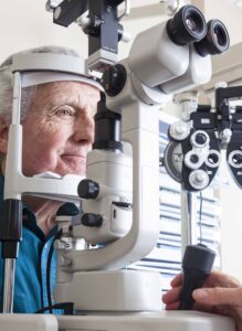 Optometrist giving eye exam to senior patient