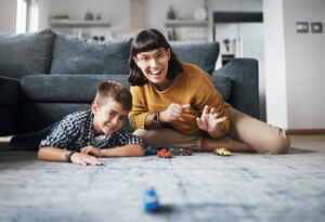 Shot of a mother and her little son playing with toy cars together at home